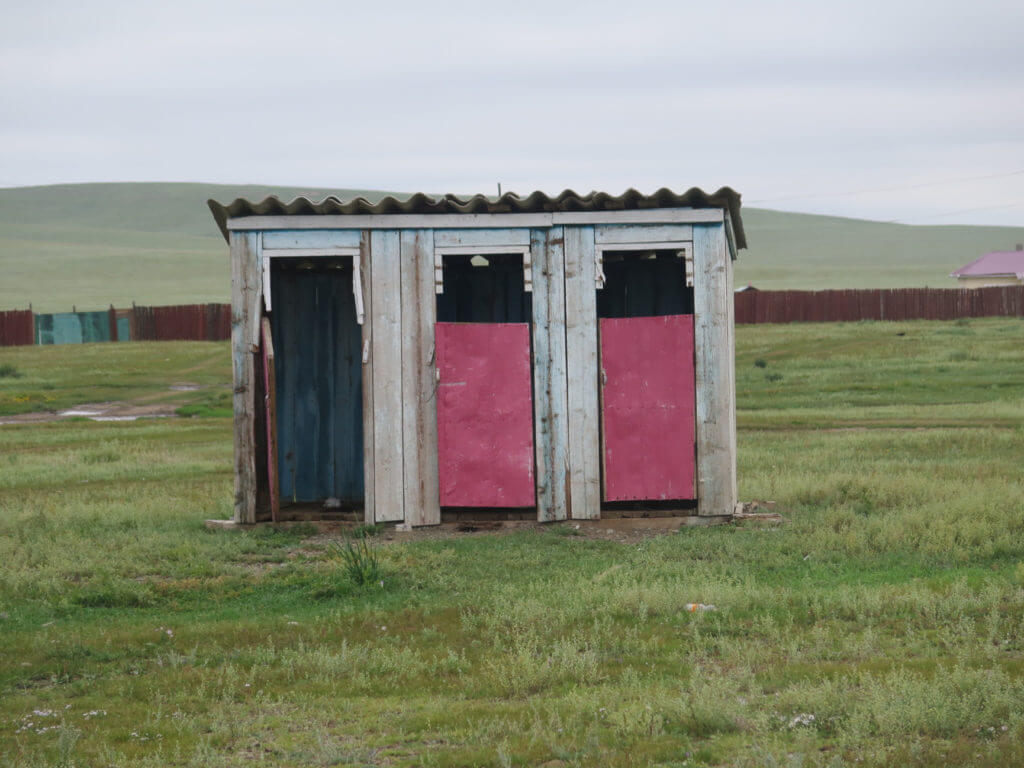 Plumpsklo unterwegs in der Mongolei, alt und dreckig, es fehlt eine Tür