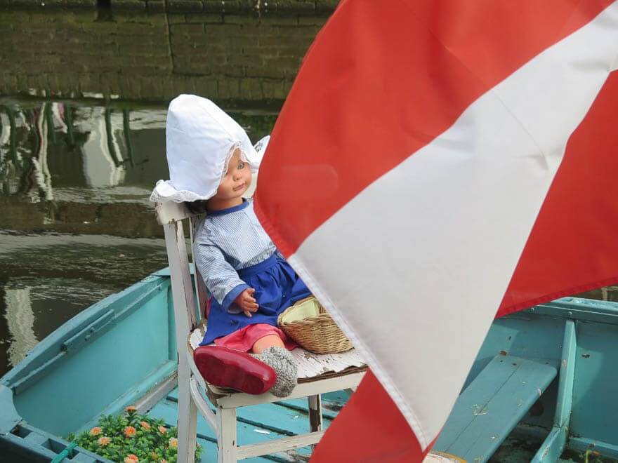 Puppe in niederländische Tracht im Boot mit rot-weiße Fahne